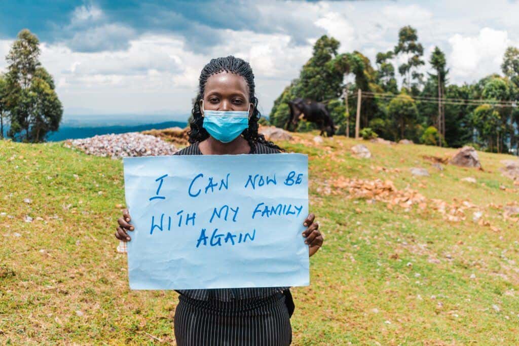 A fistula patient from Kenya holds up a sign that says, 